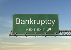 A highway exit sign, marked "Bankruptcy, Next Exit".